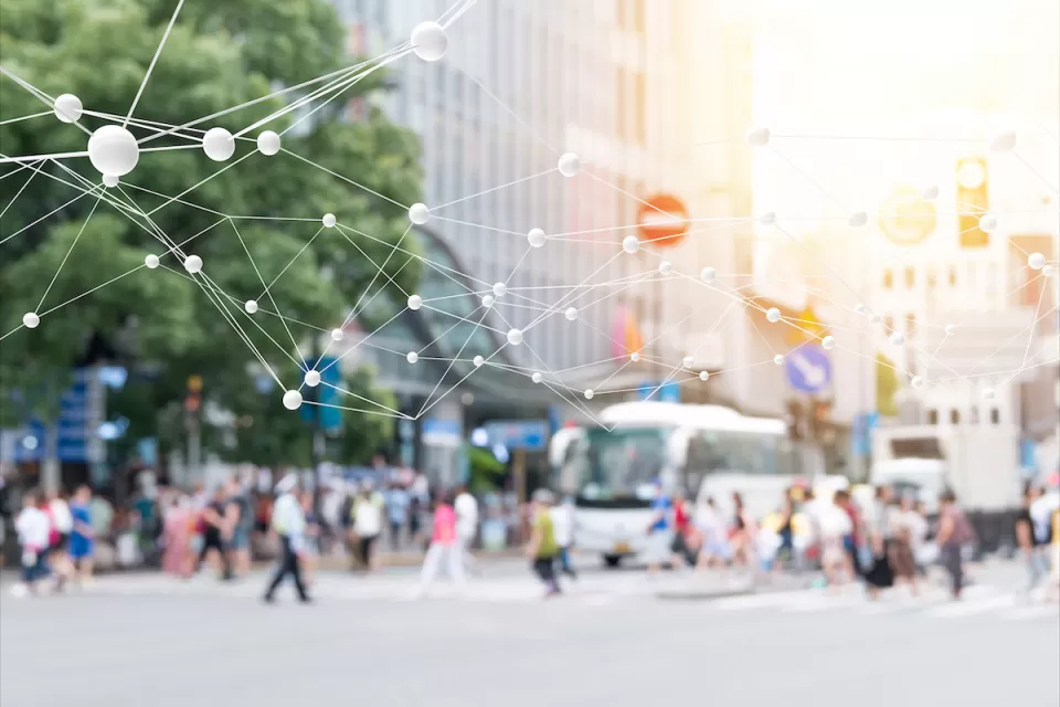 Blurred image of pedestrians on busy street with 'smart city' network rendering superimposed.